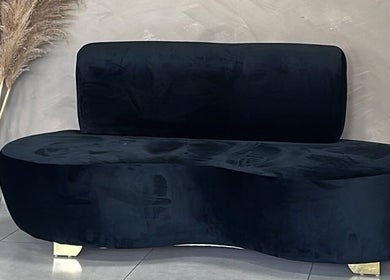 Elegant dark sofa in Zoteya Beauty Salon's calming Sandton, Gauteng, ZA setting with pampas grass decor.
