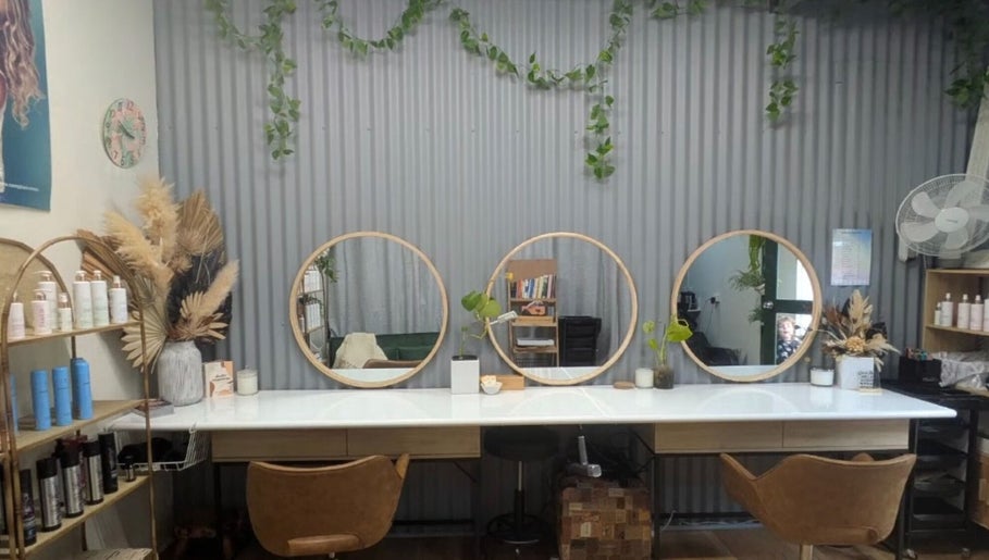 Modern salon interior at Sarah Jane Hair Craft, Melbourne, Victoria, AU, featuring round mirrors and stylish decor.