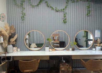 Modern salon interior at Sarah Jane Hair Craft, Melbourne, Victoria, AU, featuring round mirrors and stylish decor.