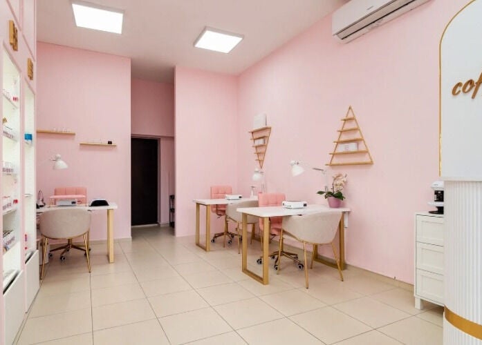Интериор на салон Hit Nails Bulgaria, София, Област София, BG, с розови стени и модерни работни места.