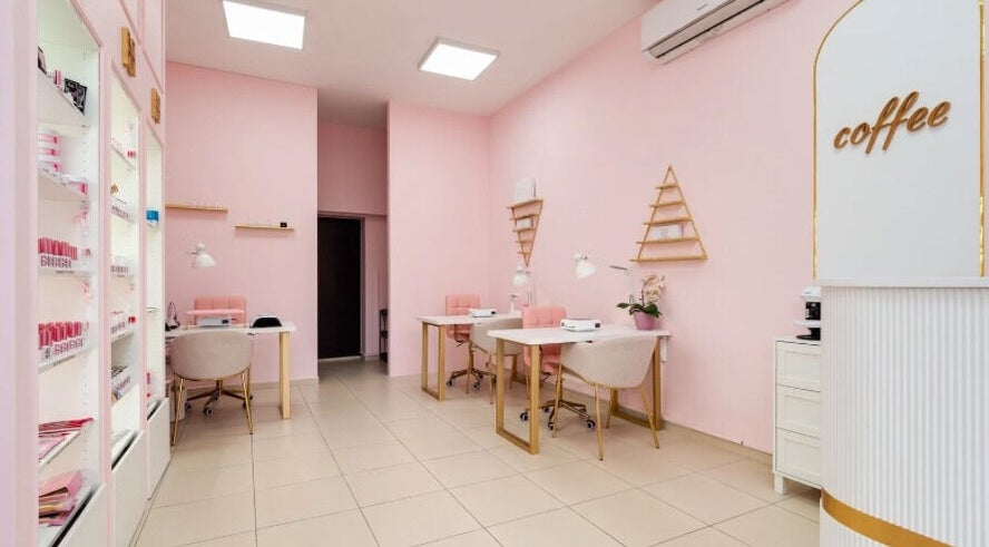 Интериор на салон Hit Nails Bulgaria, София, Област София, BG, с розови стени и модерни работни места.