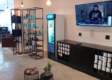 Interior view of St Tropez Homme Barbershop in Cape Town, Western Cape, ZA with modern decor and comfortable seating.