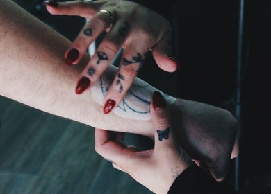 Close-up of tattoo artist's hands at Indecisive Create, Auckland, Auckland, NZ, applying a tattoo design.
