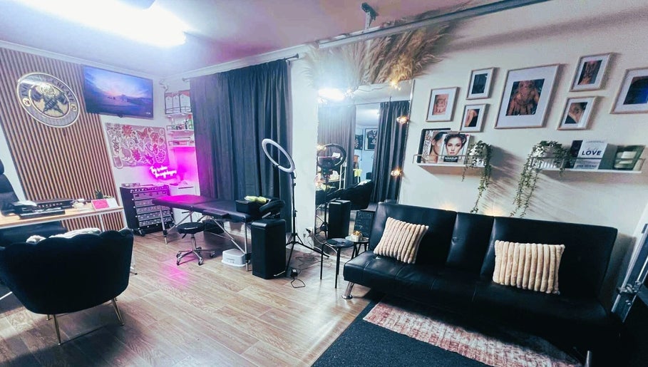 Elegant interior of Indecisive Create, Auckland with seating, neon art, and mirrors in a cozy setup.