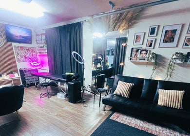 Elegant interior of Indecisive Create, Auckland with seating, neon art, and mirrors in a cozy setup.