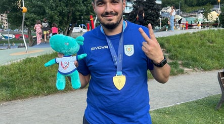 Man in park holding toy and medal near AC Physiotherapy, Lemesos, Lemesos, CY.