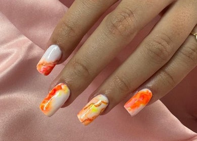 Nail art lumineuse à 'Una'Una, Saint-avé, Bretagne, FR. Design marbré orange vibrant sur fond satin rose.