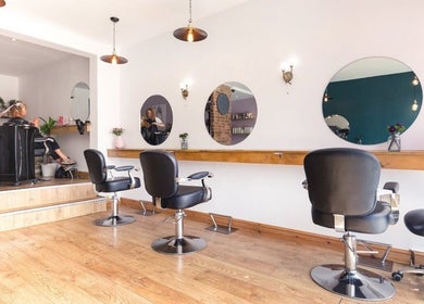 Interior of Kyleramsdenhair Co/Cobane in Stockport, England, showcasing modern salon chairs and mirrors.