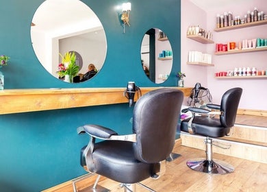 Chic interior of Kyleramsdenhair Co/Cobane in Stockport, England, GB. Modern salon chairs and vibrant decor.