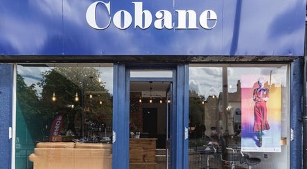 Kyleramsdenhair Co/Cobane storefront with blue signage in Stockport, England, GB, displaying a vibrant atmosphere.