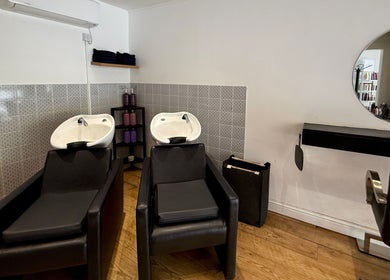 Modern hair wash station at Kyleramsdenhair Co/Cobane, Stockport, England, GB, featuring sleek black chairs.