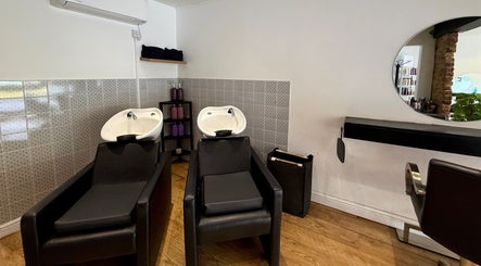 Modern hair wash station at Kyleramsdenhair Co/Cobane, Stockport, England, GB, featuring sleek black chairs.