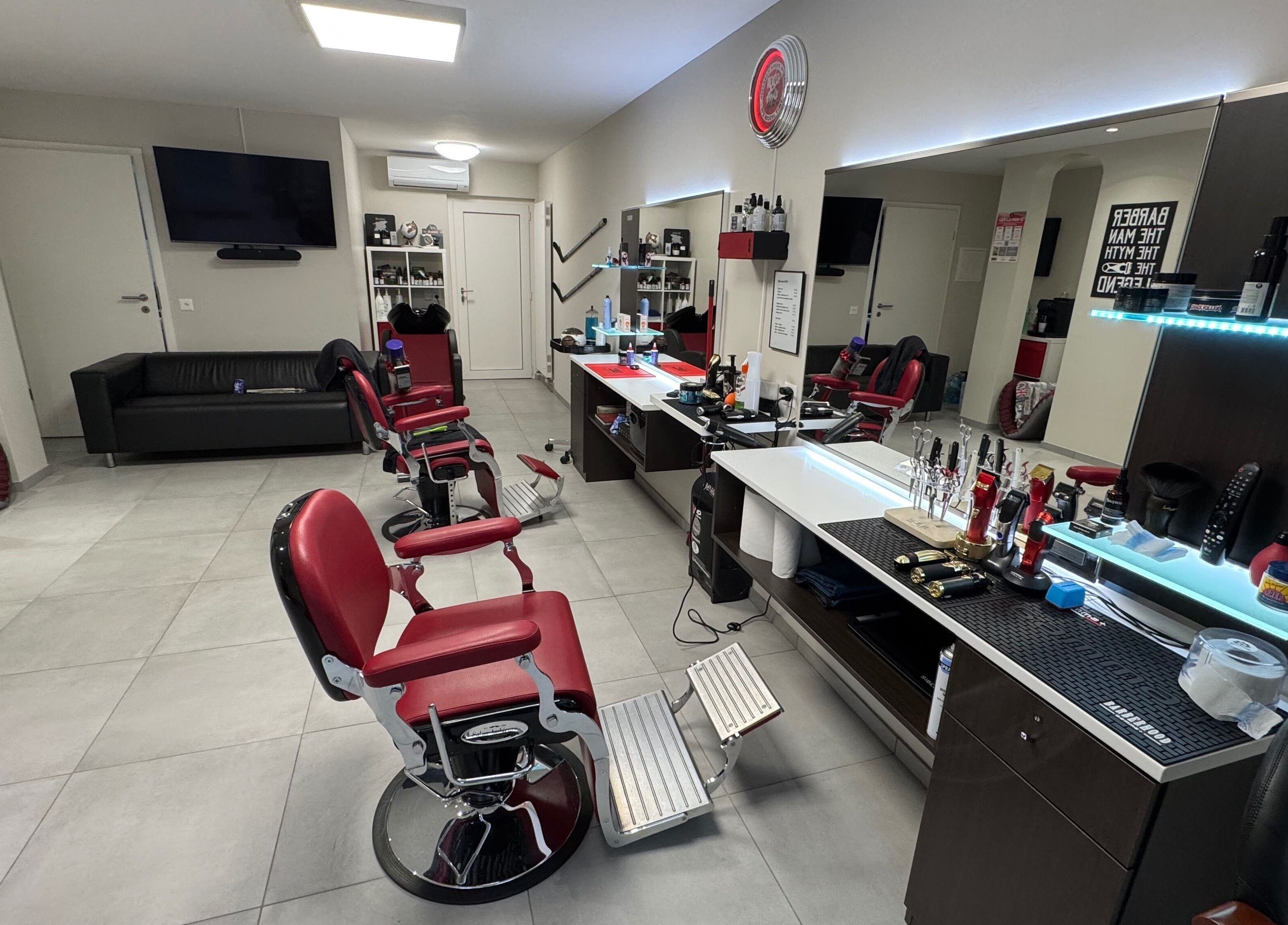 Interno di Il Barbiere di Cureglia, salone moderno a Cureglia, Ticino, CH con sedie rosse e arredamento raffinato.