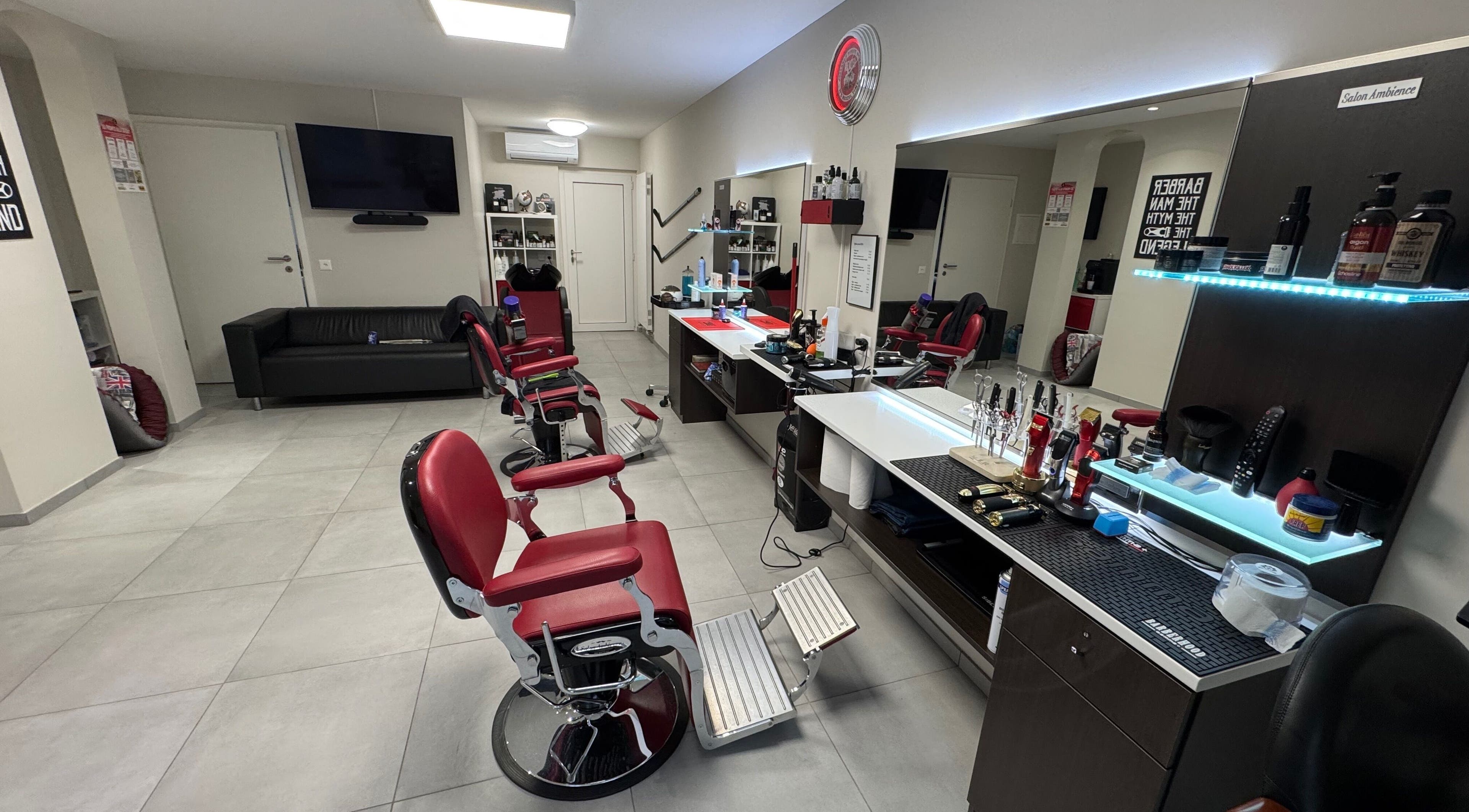 Interno di Il Barbiere di Cureglia, salone moderno a Cureglia, Ticino, CH con sedie rosse e arredamento raffinato.