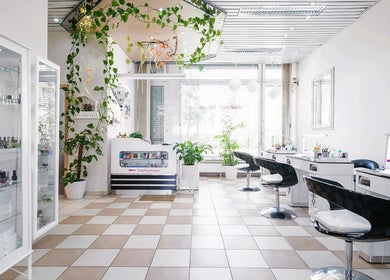 Nội thất sang trọng tại Samuel Shop Nails ở Berlin, Berlin, DE với cây xanh và bàn trang điểm hiện đại.