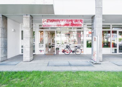 Mặt tiền Samuel Shop Nails ở Berlin, Berlin, DE, với biển hiệu sáng và xe đạp.