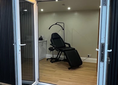 Stylish treatment room at Studio Twenty Seven, Clevedon, England, GB with a reclining chair and modern decor.