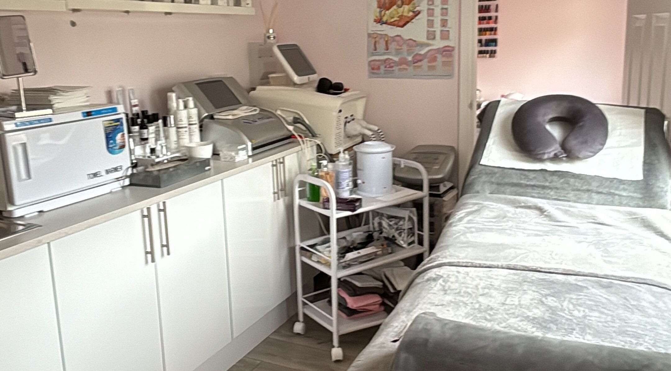 Relaxing treatment room at Bellissima, Borehamwood, England, GB with spa bed, equipment, and products.