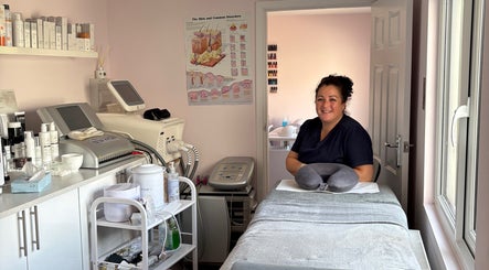 Cozy treatment room at Bellissima in Borehamwood, England with smiling therapist and modern equipment.