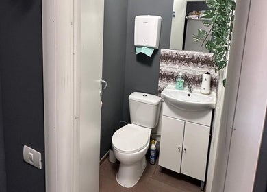 Baia modernă a salonului Frizerie din București, București, RO, cu accente elegante și mobilier alb.