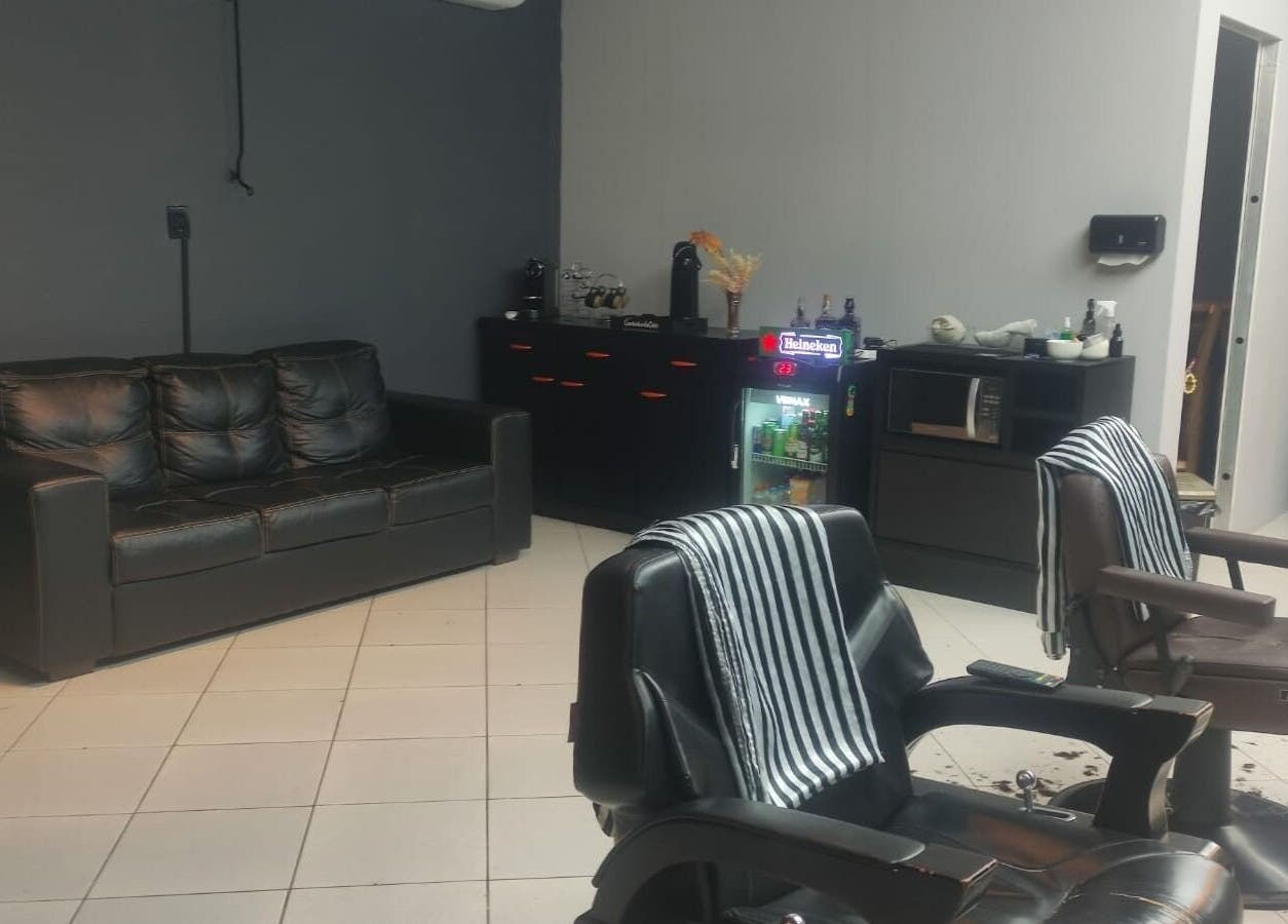 Interior moderno da Barbearia Dom Pascoal, Santa Catarina, BR, com cadeiras de couro elegantes e móveis confortáveis.