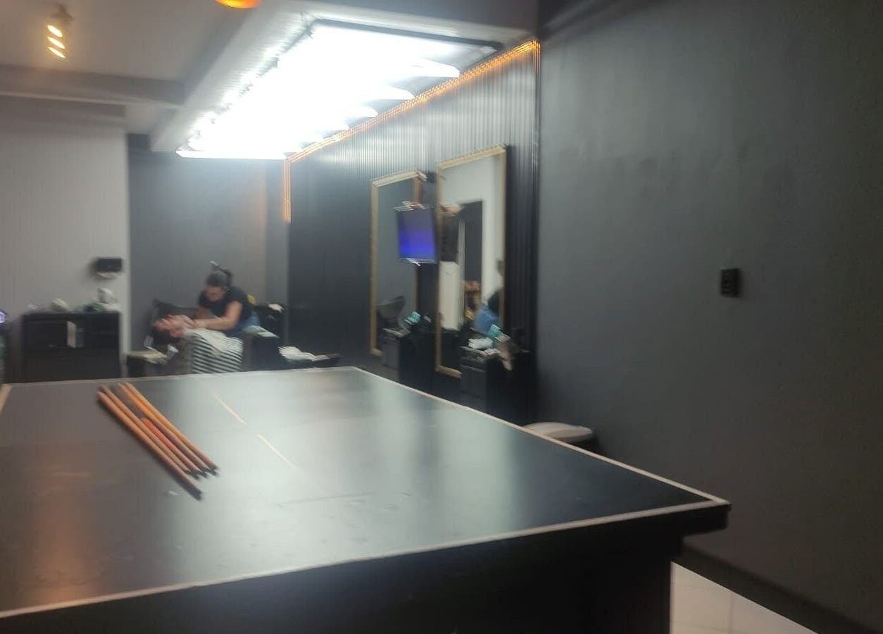 Interior moderno da Barbearia Dom Pascoal em Santa Catarina, com mesa de sinuca e espelhos.