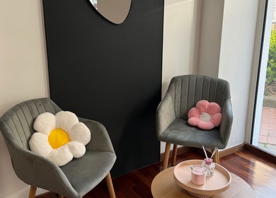 Coin détente avec fauteuils et coussins floraux chez Beauty Skin, Châtelet, Région Wallonne, BE.