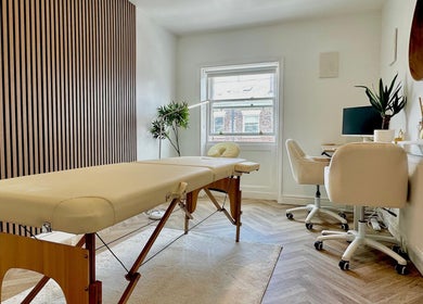 Elegant treatment room at Nutritionally, Liverpool, England, GB, featuring modern decor and massage table.