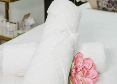 Fluffy white towels with a pink flower at Laleh Nail and Beauty, Cape Town, Western Cape, ZA.