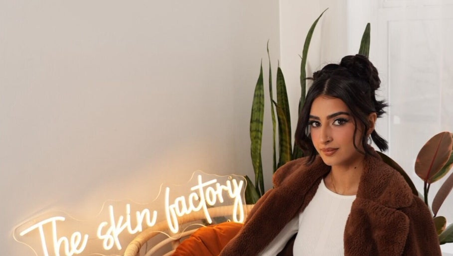 A woman sits at The Skin Factory Inc, cozy ambiance with plants in Abbotsford, British Columbia, CA.