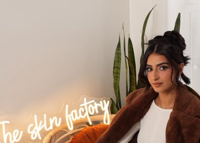 A woman sits at The Skin Factory Inc, cozy ambiance with plants in Abbotsford, British Columbia, CA.
