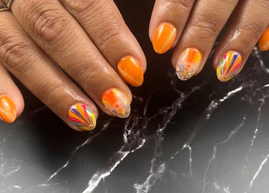 Manucure vibrante réalisée à Licyca, Plassac, Nouvelle-Aquitaine, FR. Ongles oranges avec motifs colorés.