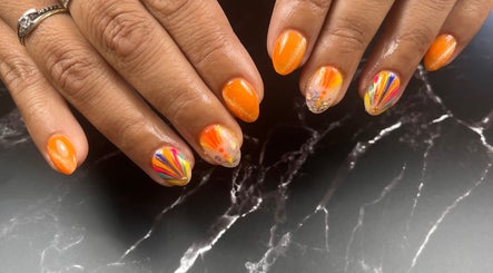Manucure vibrante réalisée à Licyca, Plassac, Nouvelle-Aquitaine, FR. Ongles oranges avec motifs colorés.