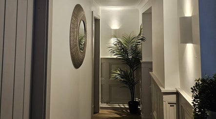 Sophisticated hallway at York Medical Aesthetics and Massage, York, England, GB, featuring a mirror and plant.