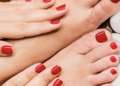 Manicured hands and feet with red polish at Nail's by yilm, Lakeland, Florida, US.