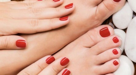 Manicured hands and feet with red polish at Nail's by yilm, Lakeland, Florida, US.