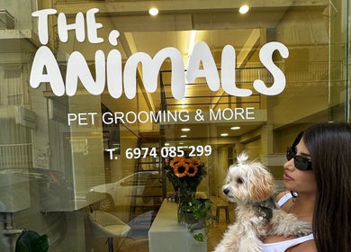 Εξωτερική όψη του The Animals - Pet Grooming and More στην Αθήνα, GR με μία γυναίκα κρατώντας σκύλο.