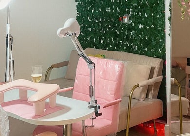 Espacio elegante en En Buenas Manos, Bonita Springs, Florida, US, con sillas rosas y decoración verde.