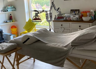 Cozy therapy room at Boston Spa Acupuncture and Yoga in Leeds, England, GB with massage table and infrared lamps.