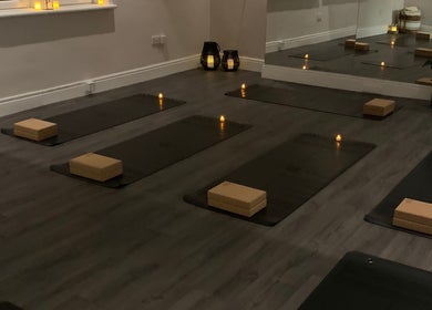 Candlelit yoga studio setup at Boston Spa Acupuncture and Yoga, Leeds, England, GB, with mats and props.