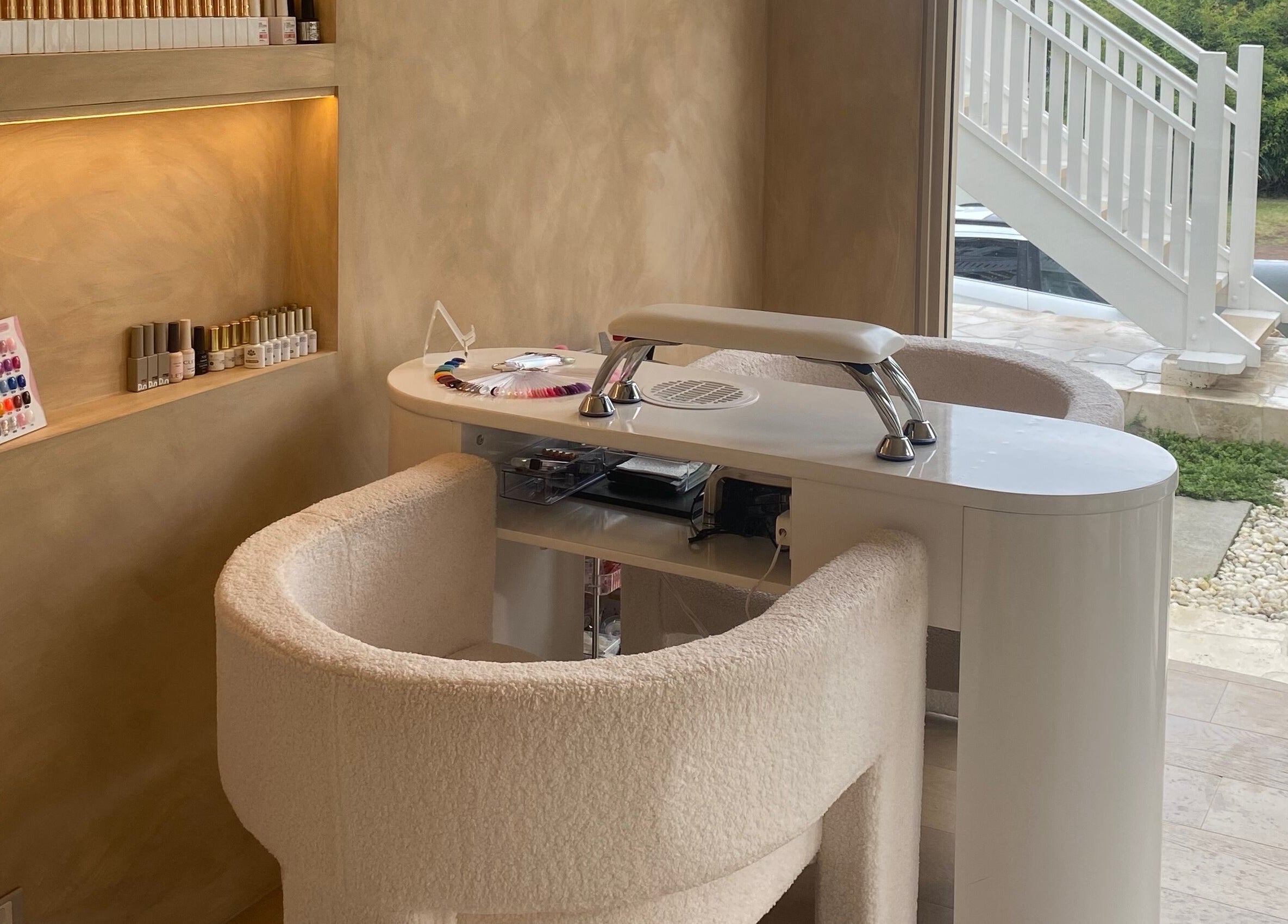 Elegant nail salon station at Sugaplum Studio in Albion, Queensland, AU, featuring plush chairs and nail polish display.