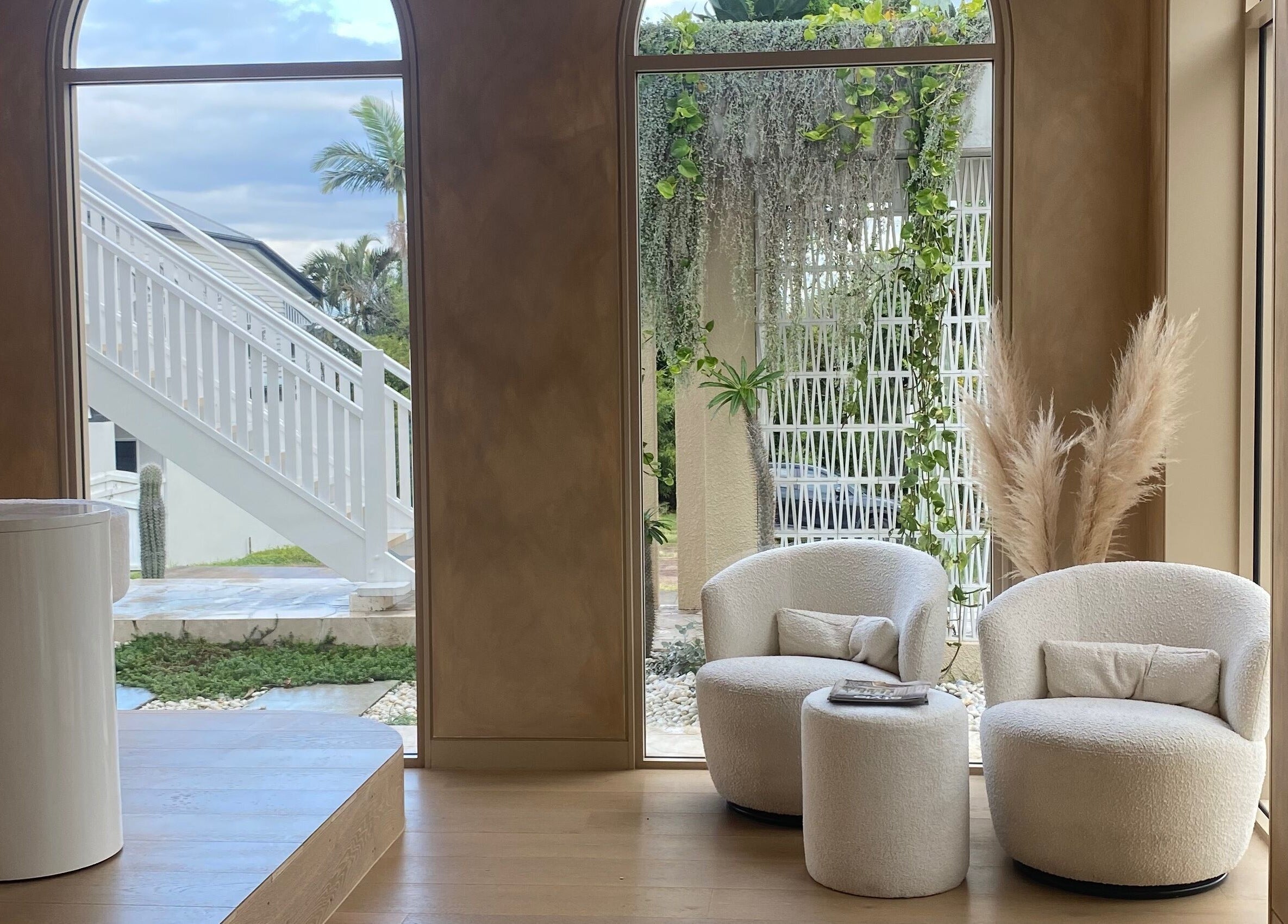 Lush seating area at Sugaplum Studio in Albion, Queensland, AU with comfortable chairs and greenery.