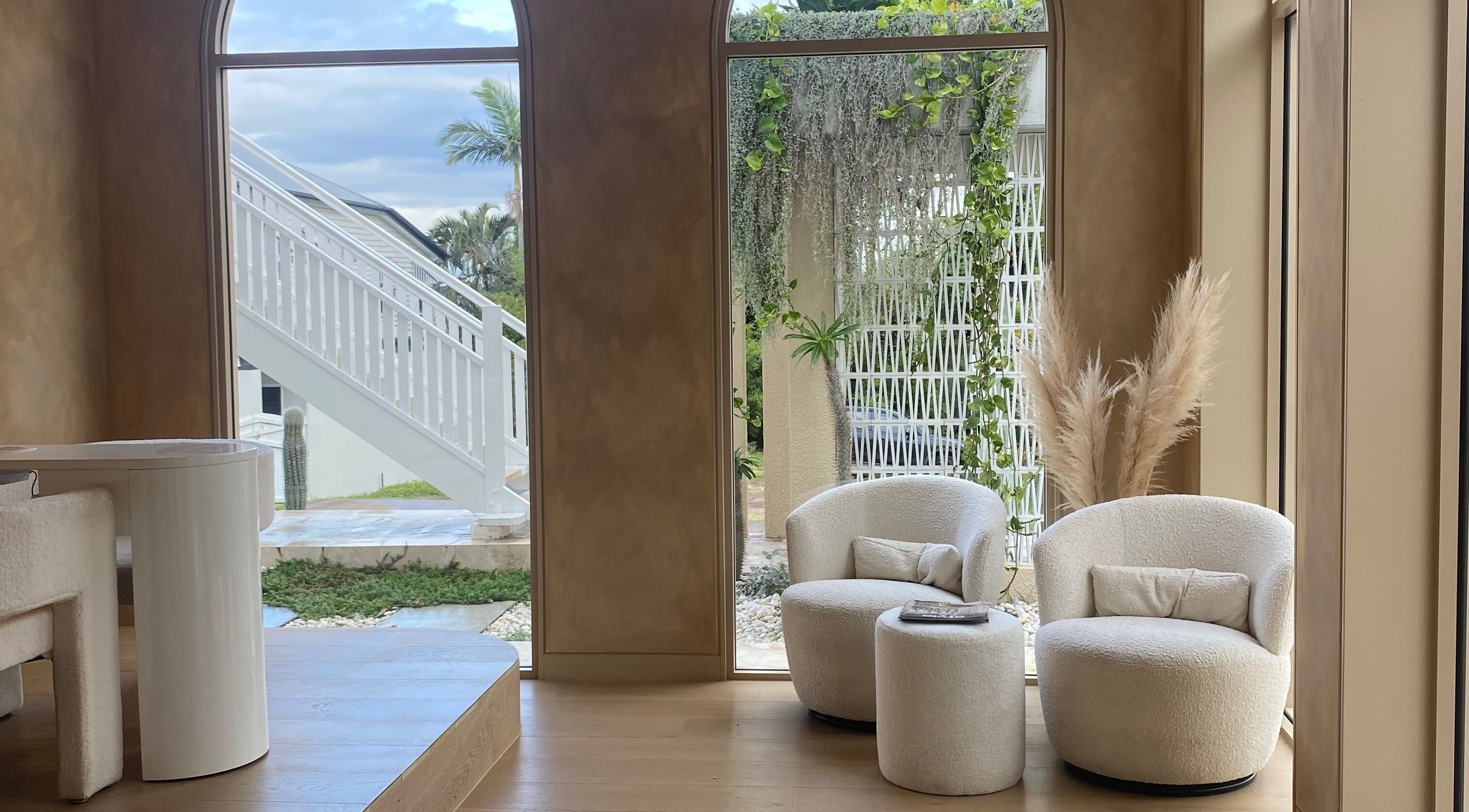 Lush seating area at Sugaplum Studio in Albion, Queensland, AU with comfortable chairs and greenery.