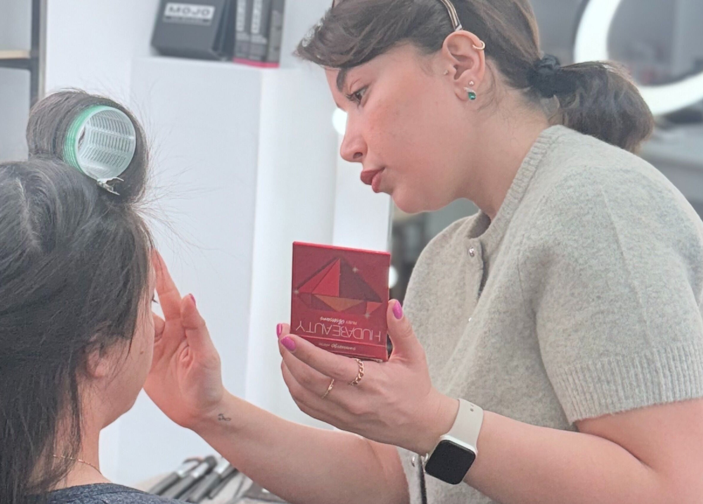 Makeup artist enhancing client beauty at Hair By Radoushka, London, England, GB.