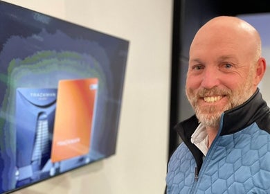 Happy guest at Adam Bland Golf, Flagstaff Hill, South Australia, AU, near a displayed screen.