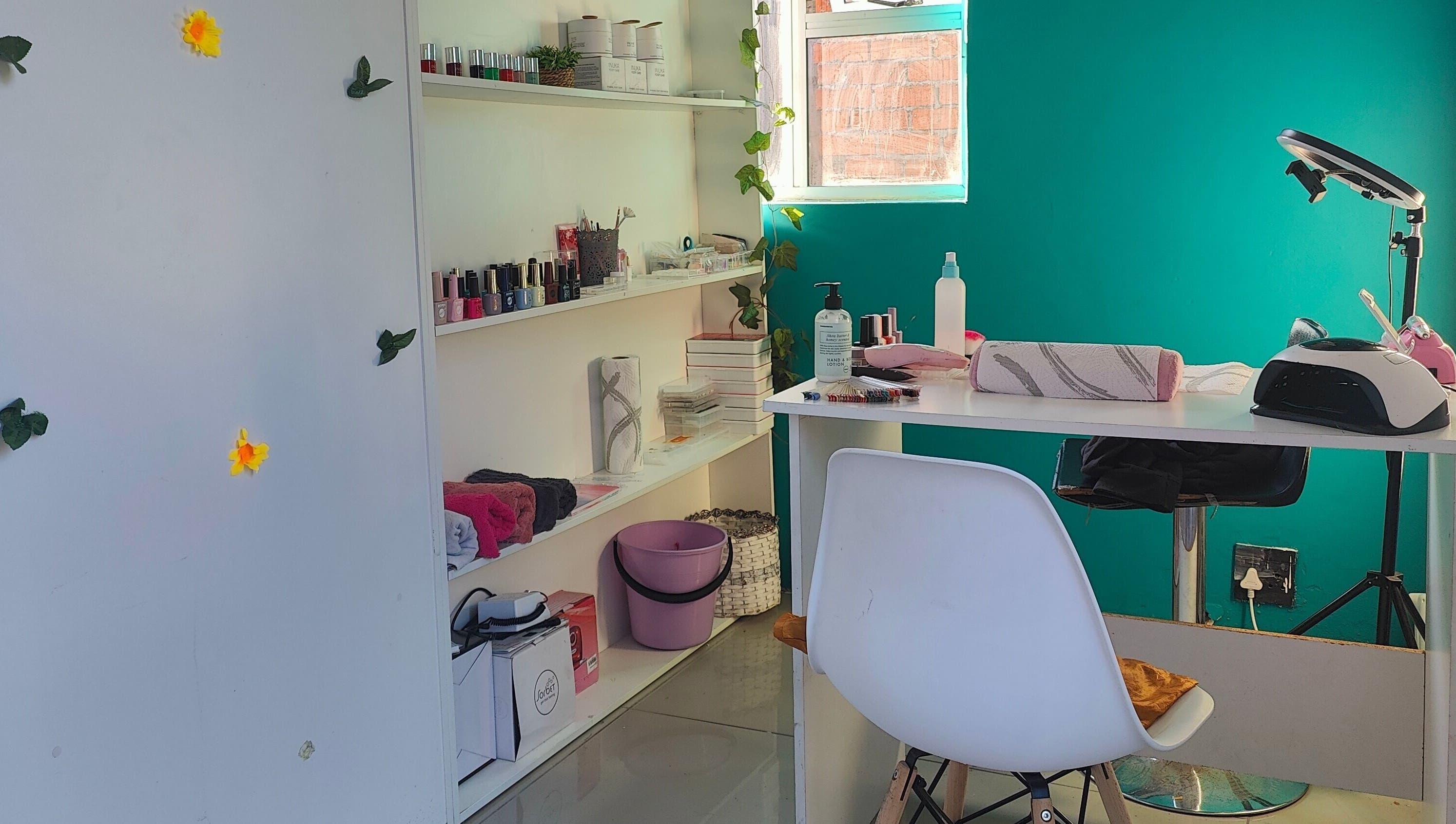 Cozy nail station at Nails by Jordan in Cape Town, Western Cape, ZA featuring polish display and comfortable seating.