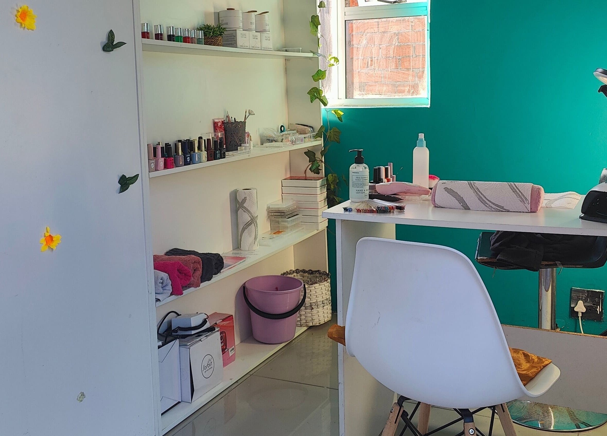Cozy nail station at Nails by Jordan in Cape Town, Western Cape, ZA featuring polish display and comfortable seating.