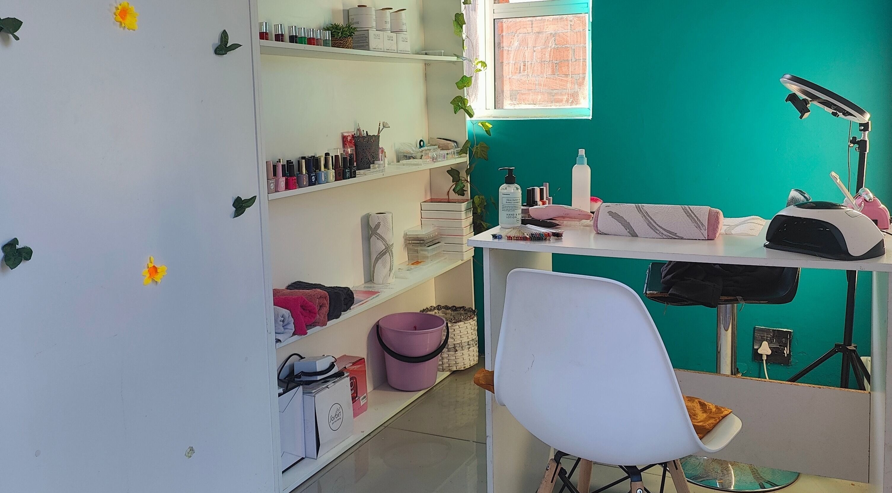 Cozy nail station at Nails by Jordan in Cape Town, Western Cape, ZA featuring polish display and comfortable seating.