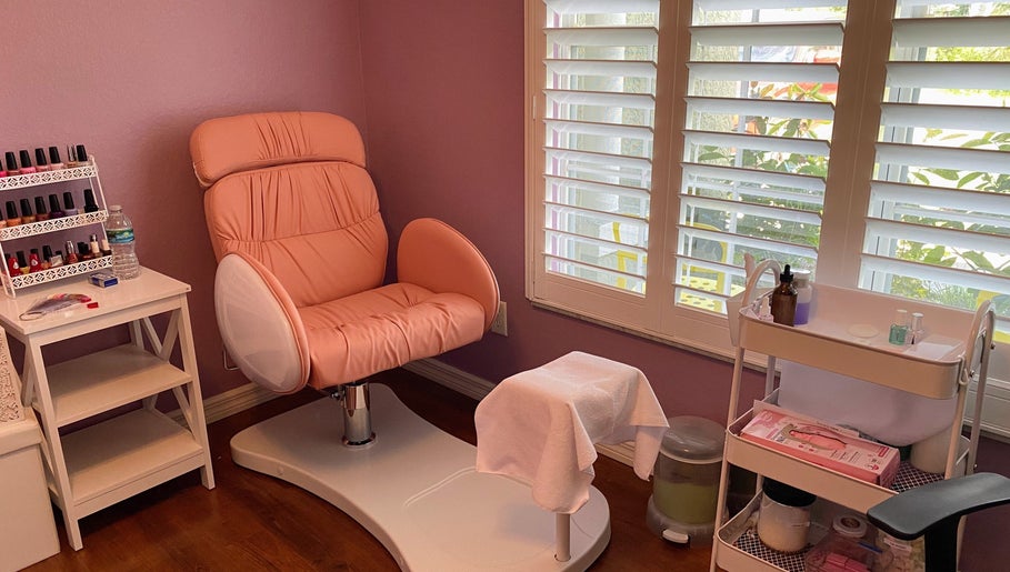 A cozy nail care station at Nail Love by Megan in North Port, Florida, US with a pink chair and manicure tools.