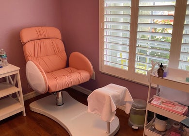 A cozy nail care station at Nail Love by Megan in North Port, Florida, US with a pink chair and manicure tools.